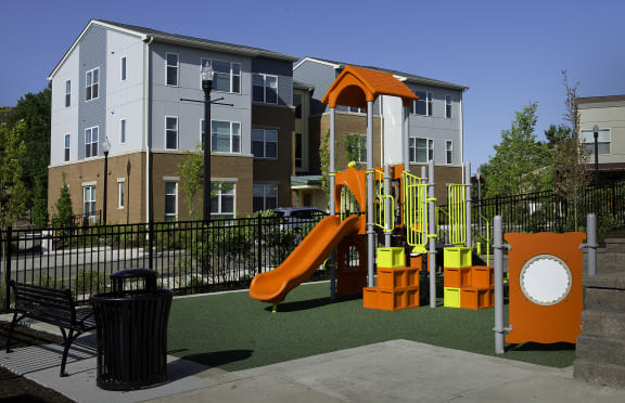 a playground at an apartment complex with a swing set