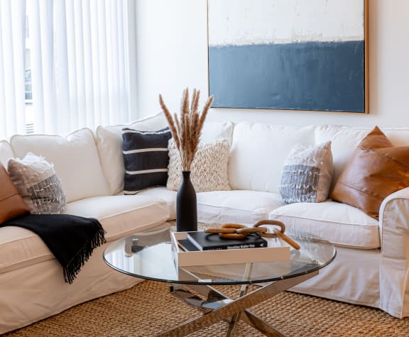 a living room with a white couch and a glass coffee table