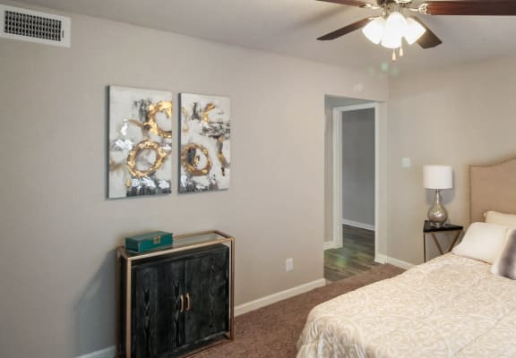 a bedroom with a large bed and a ceiling fan at Seacrest Apartments, Garland, TX, 75044