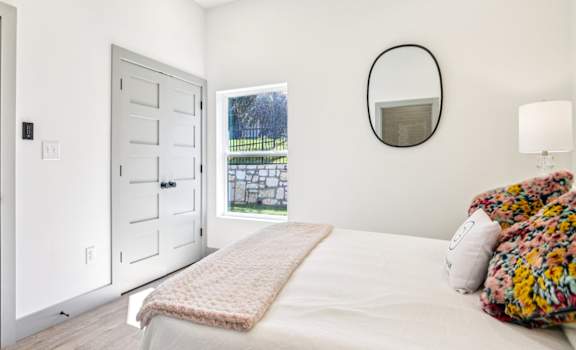 A bedroom with a bed, a dresser, and a mirror.