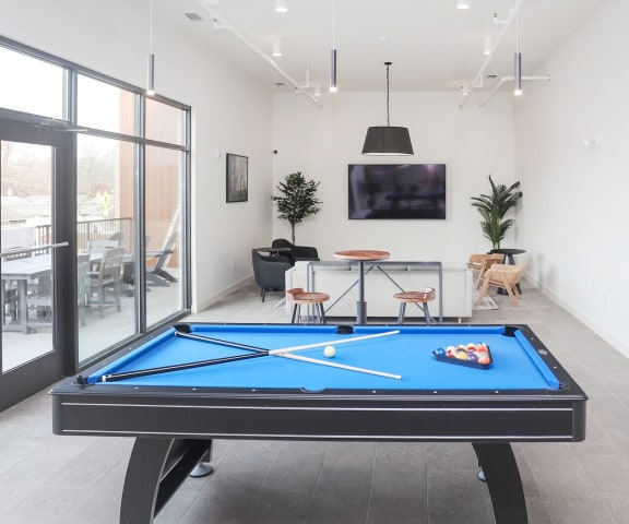 a games room with a pool table and a tv