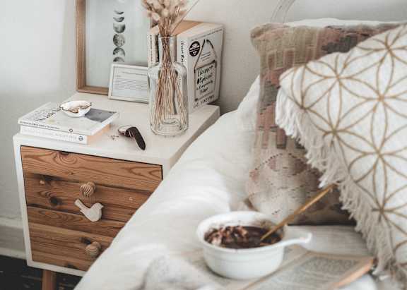 Bedroom featuring a bed and a nightstand with a vase of flowers.