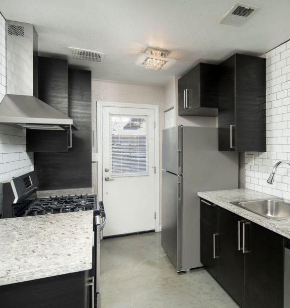 a kitchen with stainless steel appliances and marble counter tops