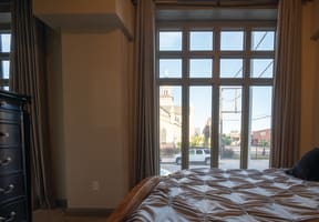 a bedroom with a bed and a large window