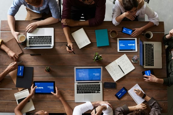 group of people sitting around a table with laptops at South Falls Tower, Richmond, VA, 23224