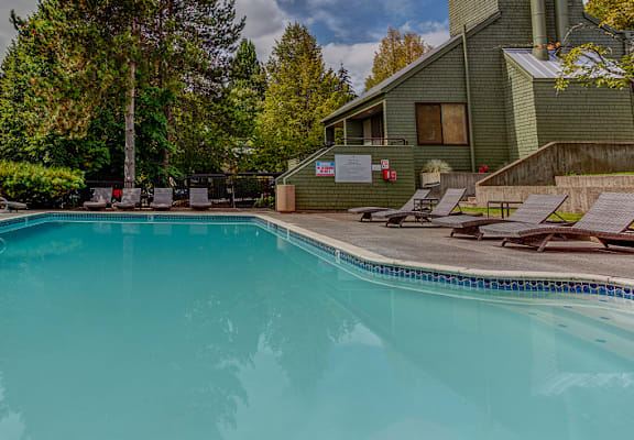 Trees and patio by the pool at Commons at Redwood Creek Apartments, Beaverton, Oregon