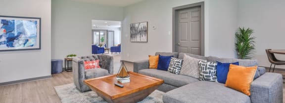 a living room with a couch a table and chairs and a sliding glass door
