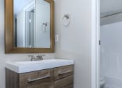 Thumbnail 13 of 22 - a bathroom with a sink and a shower and a mirror