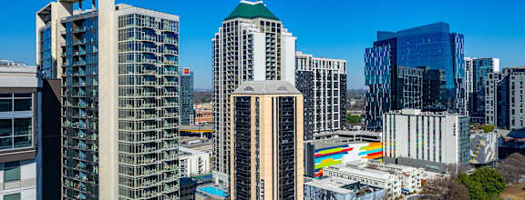 A cityscape with various buildings and a clear blue sky.