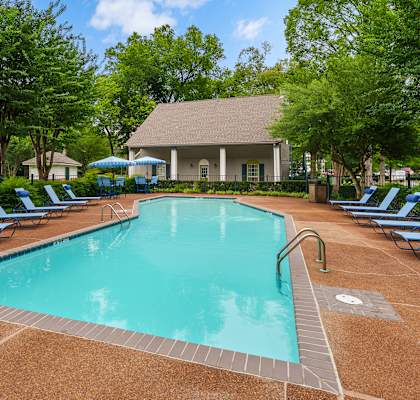 A large swimming pool surrounded by blue lounge chairs.