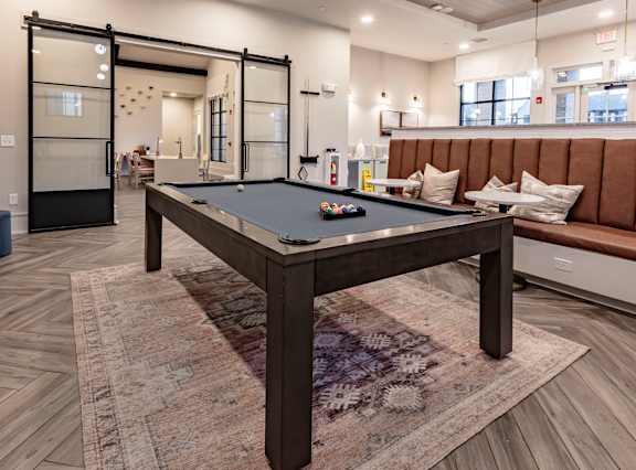 a billiards table in a clubhouse with couches