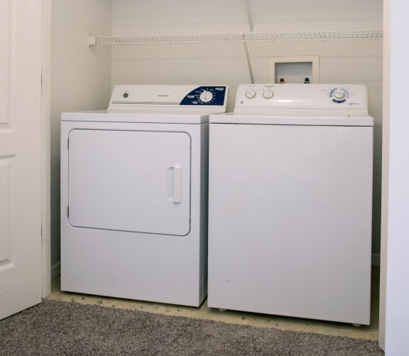 a washer and dryer in a room with a white wall and a door