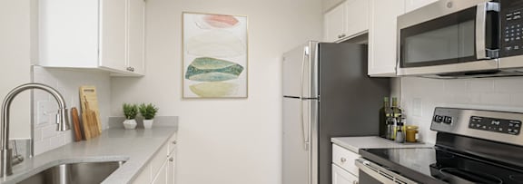 a kitchen with stainless steel appliances and white cabinets