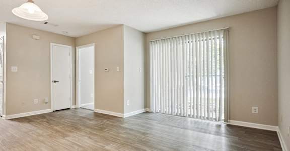 A large empty room with wooden floors and white walls.