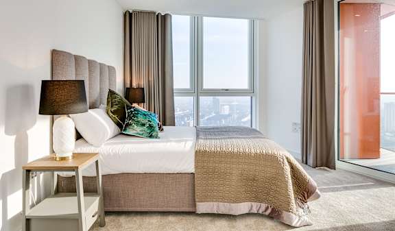 a bedroom with a bed and a large window