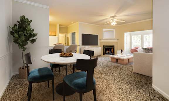 A living room with a white table and blue chairs. at Village on the Lake Apartments, Apartments, Spring Lake, NC