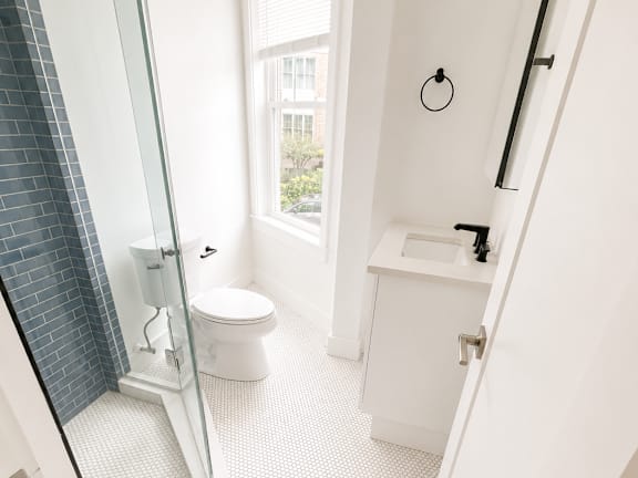 A white bathroom with a walk in shower.