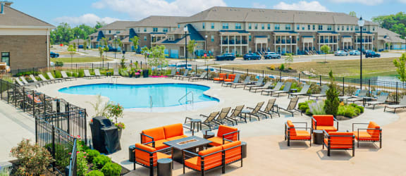 a group of orange lounge chairs next to a swimming pool