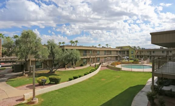 A large grassy area in front of apartment buildings.