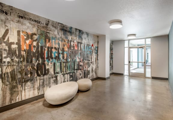 Clubhouse Foyer with Graffiti Accent Wall with Contemporary Round Seats