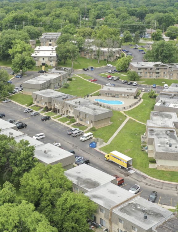 an aerial view of a city with cars parked in a parking lot