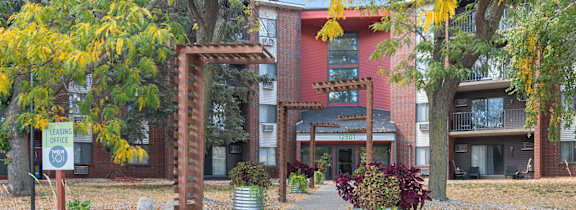 A brick archway leads to a building with a red and white facade.