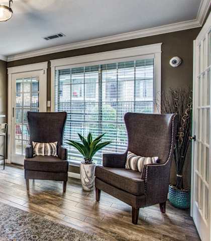 an inviting living room with a kitchen and a large window