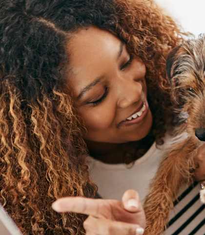 smiling woman holding dog in Gulfport, MS