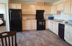 A kitchen with black appliances and wooden cabinets.