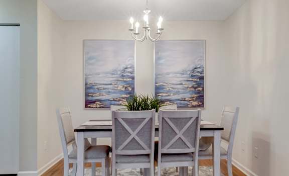 A dining room with a table set for four.