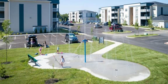 a group of children playing in a park in front of apartments