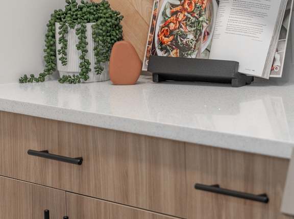 A cutting board, a knife, and a magazine are on a kitchen counter.at Vista Apartments at Edgemont, Edmonton