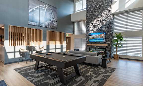 A modern living room with a pool table and a television.