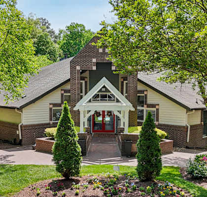 A house with a red door and a green lawn.