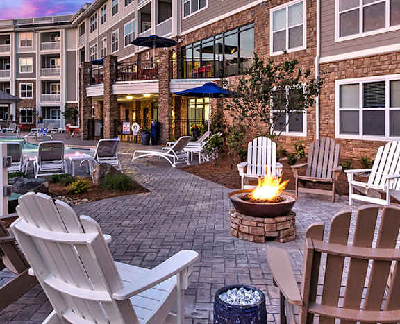 A patio with chairs and a fire pit in front of a building at Residence at Tailrace Marina, Mount Holly, NC
