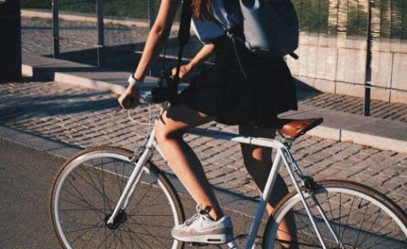 a woman is riding a bike down the street