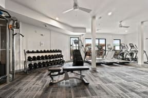 a gym with a lot of treadmills and weights