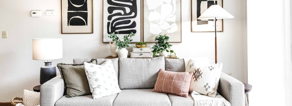 a living room with a couch and paintings on the wall