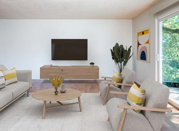 A living room with a grey couch, a wooden coffee table, and a television.