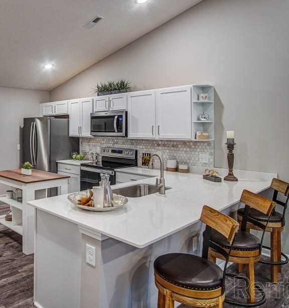 an open kitchen and dining area with a white counter top