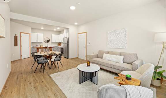 A modern living room with a dining table and grey couch.