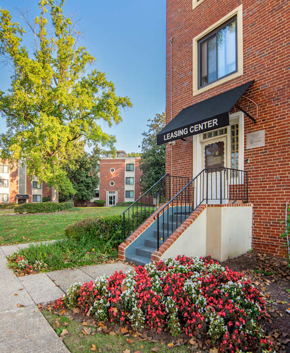 a brick building with stairs and flowers in front of it