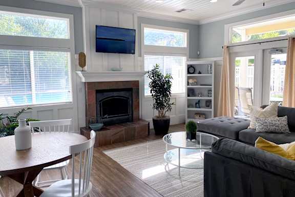 A living room with a grey couch and a fireplace.