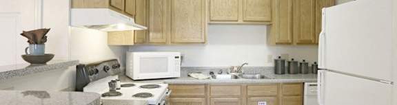 A Kitchen With Wooden Cabinets at Magnolia Court Apartments, Birmingham