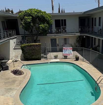 A pool surrounded by a fence and a sign that says "Property Management".