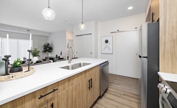 a kitchen with a large island and a stainless steel refrigerator