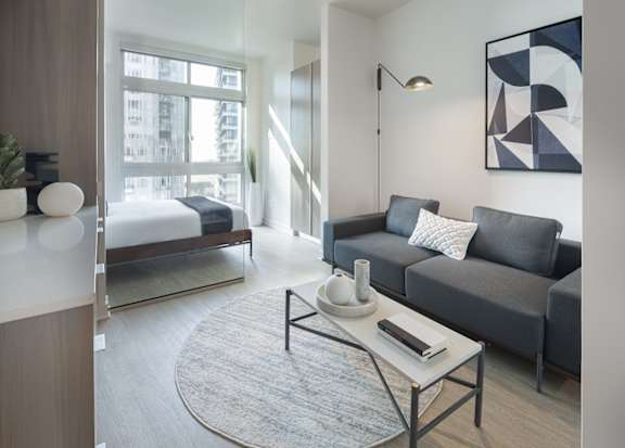 a living room with a couch and a coffee table and a bedroom with a bed at Wilshire Margot, Los Angeles, CA 90024