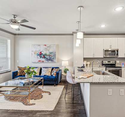 a kitchen and living room with stainless steel appliances and a granite counter top