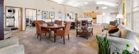 a large clubhouse kitchen and dining area with a fireplace and a table and chairs at Horace Mann apartments and townhomes in Gary, IN