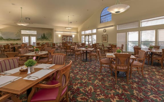 a large dining room with tables and chairs and windows